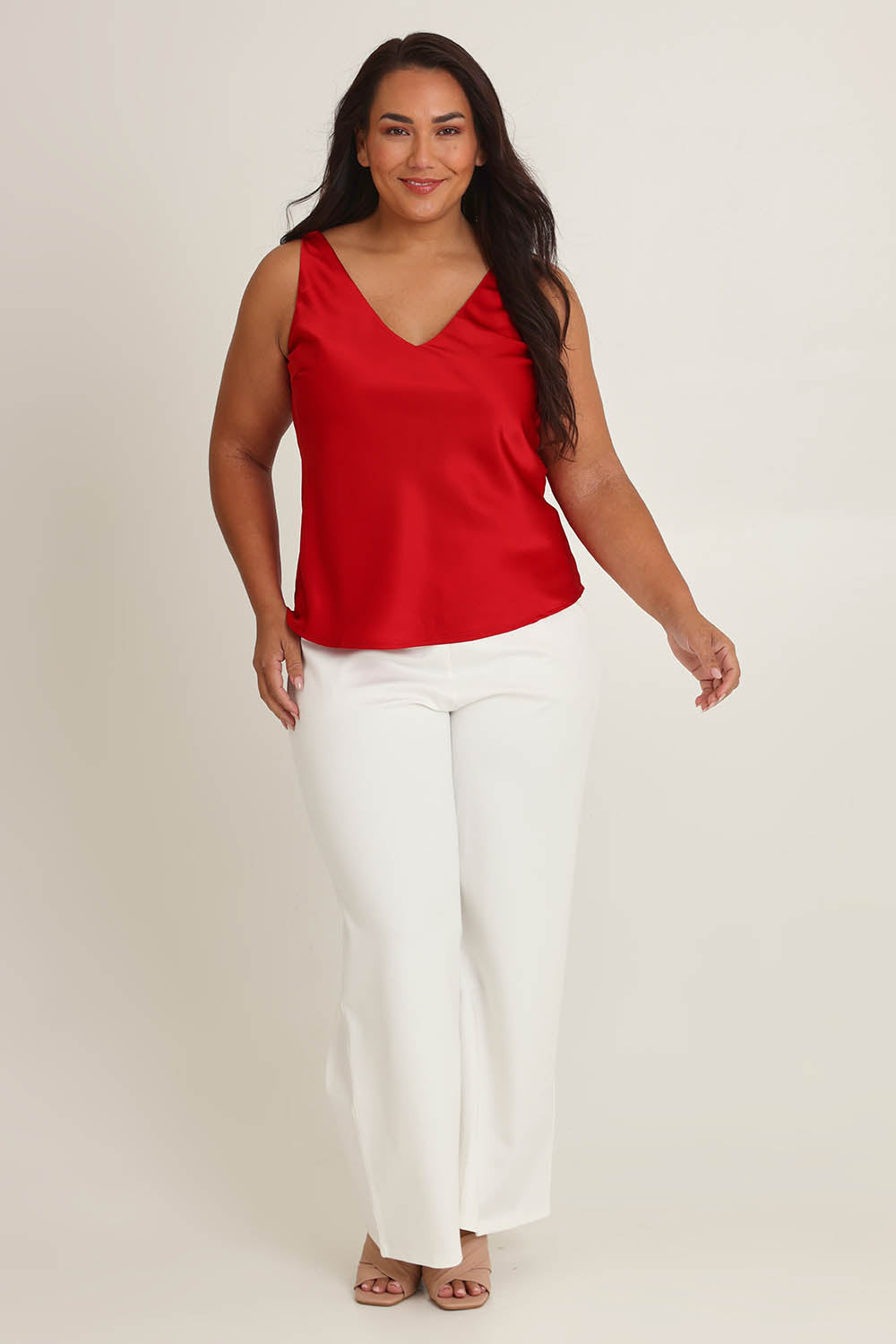 Model Ashleigh wearing size 16 of the Loulou Satin Camisole in colour Red (Red), from the front, showing the whole outfit