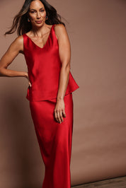 Model Madeline wearing size 10 of the Loulou Satin Camisole in colour Red (Red), from the front, showing the whole outfit