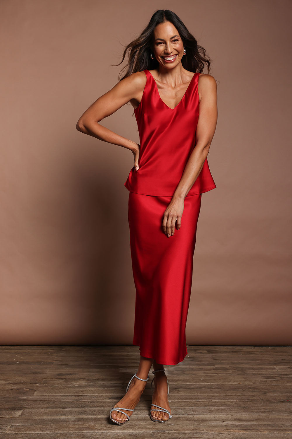 Model Madeline wearing size 10 of the Loulou Satin Camisole in colour Red (Red), from the front, showing the whole outfit