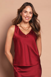 Model Madeline wearing size 10 of the Loulou Satin Camisole in colour Shiraz (Red), from the front, cropped image