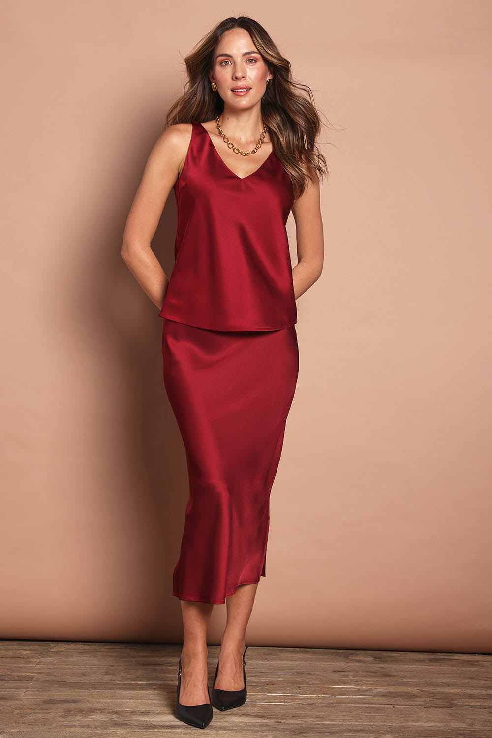 Model Madeline wearing size 10 of the Loulou Satin Camisole in colour Shiraz (Red), from the front, showing the whole outfit