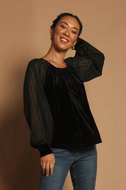 Model Katie wearing size 10 of the Leyla Velvet Blouse in colour Black (Black), from the front, showing the whole outfit