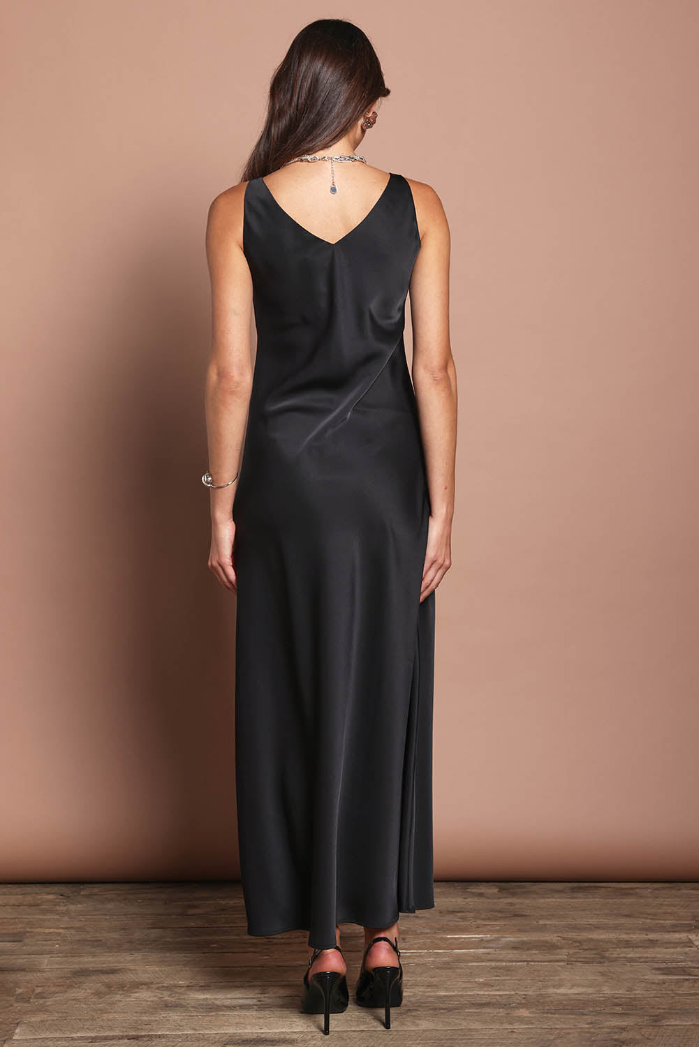 Model Madeline wearing size 10 of the Loulou Satin Slip Dress in colour Black (Black), from the back