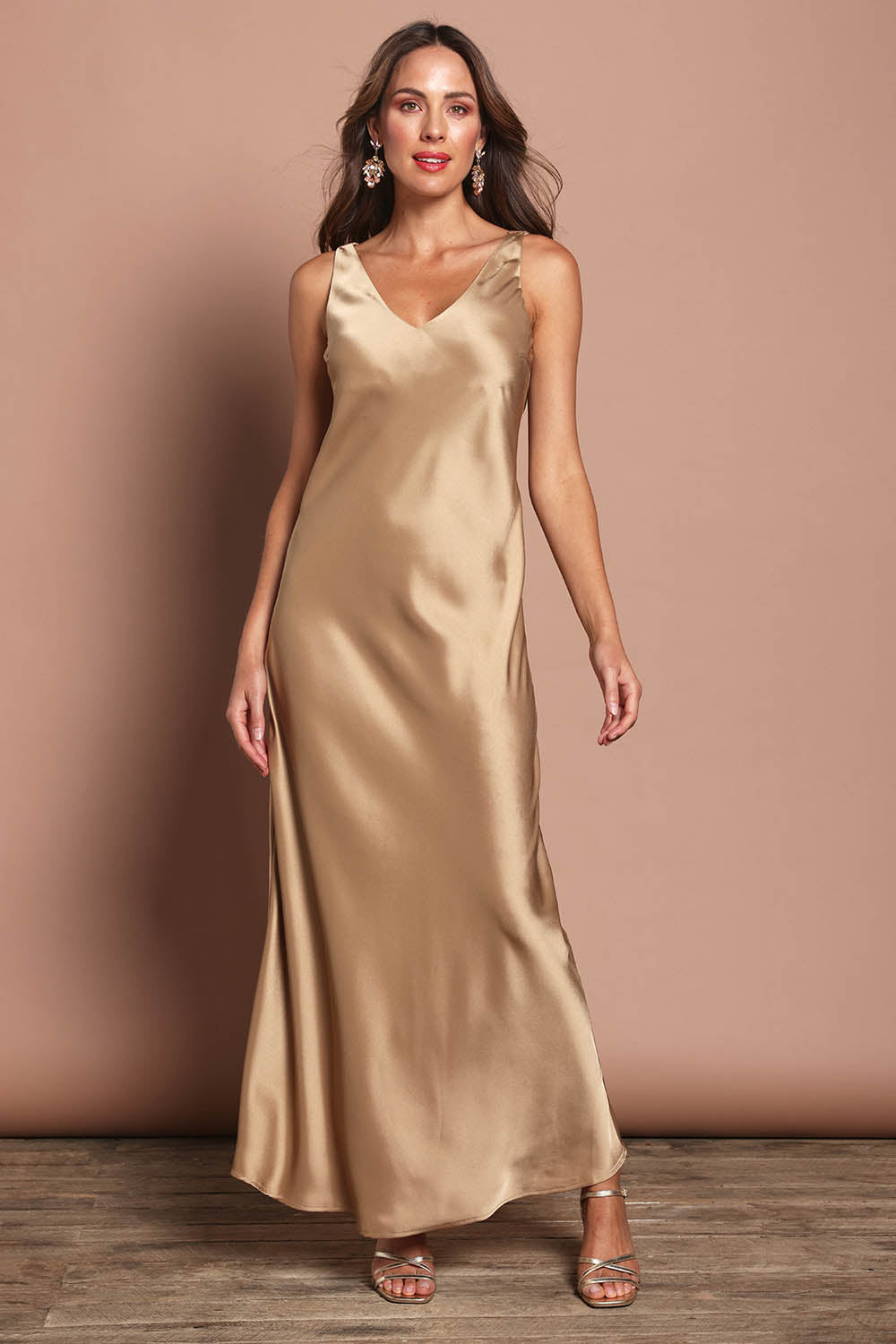 Model Madeline wearing size 10 of the Loulou Satin Slip Dress in colour Latte, from the front, showing the whole outfit