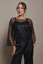 Model Madeline wearing size S of the Nina Sequin Top in colour Black (Black), from the front, cropped image
