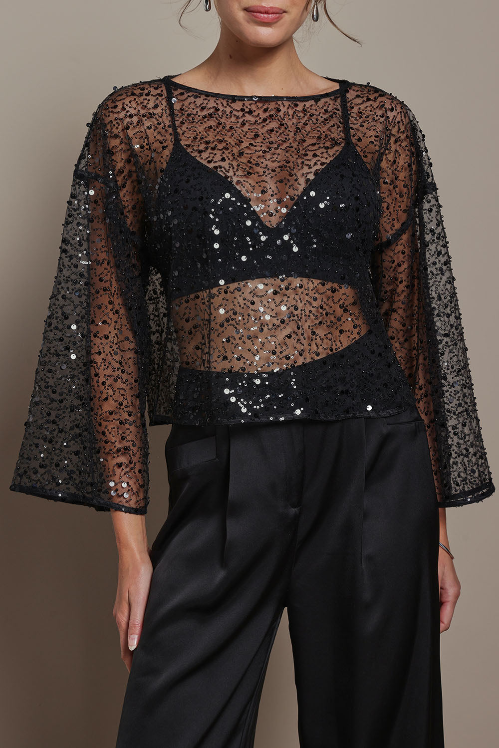 Model Madeline wearing size S of the Nina Sequin Top in colour Black (Black), from the front, cropped image