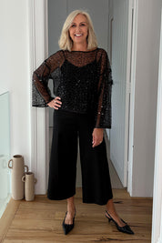 Model Sandy wearing size S of the Nina Sequin Top in colour Black (Black), from the front, showing the whole outfit