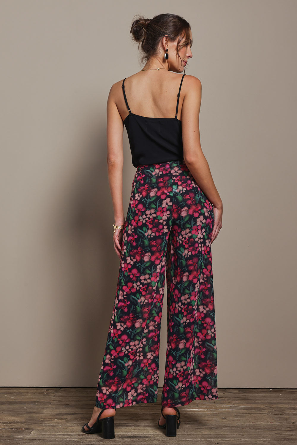 Model Madeline wearing size 10 of the Annette Pants in colour Blossom (Black), from the back