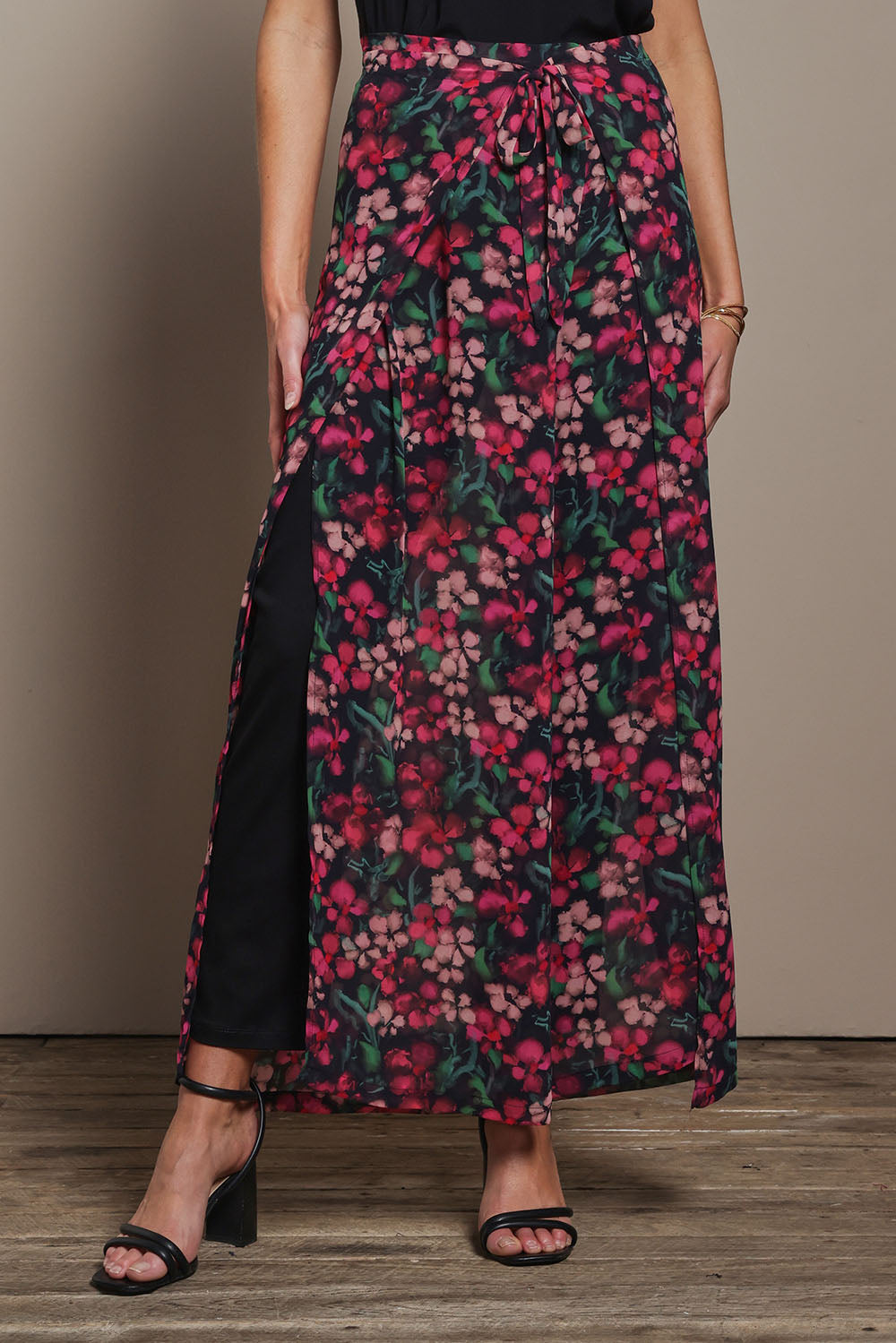 Model Madeline wearing size 10 of the Annette Pants in colour Blossom (Black), from the front, cropped image