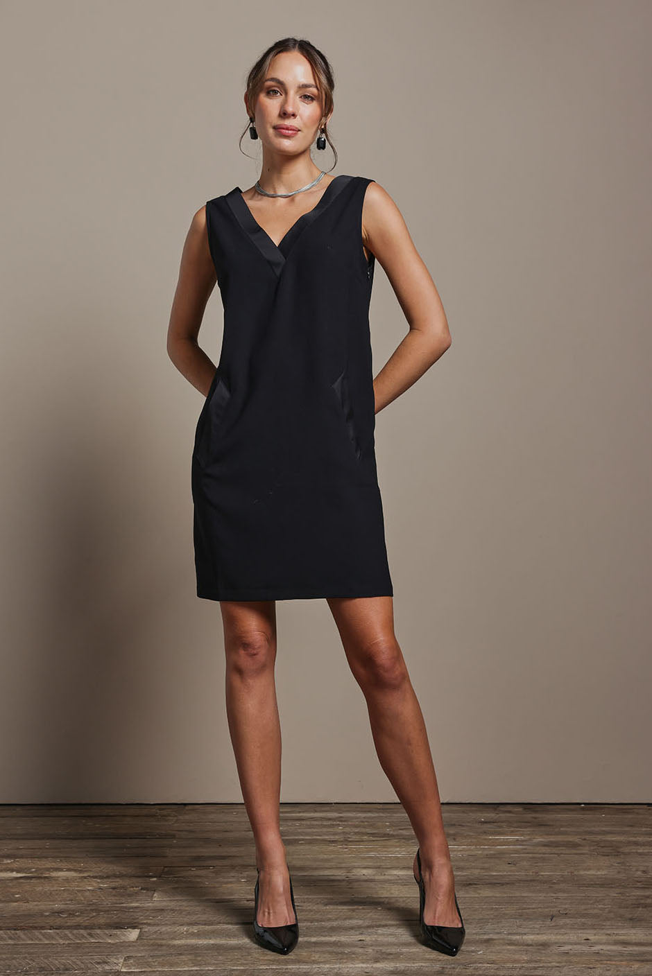 Model Madeline wearing size 10 of the Meave Tuxedo Dress in colour Black (Black), from the front, showing the whole outfit