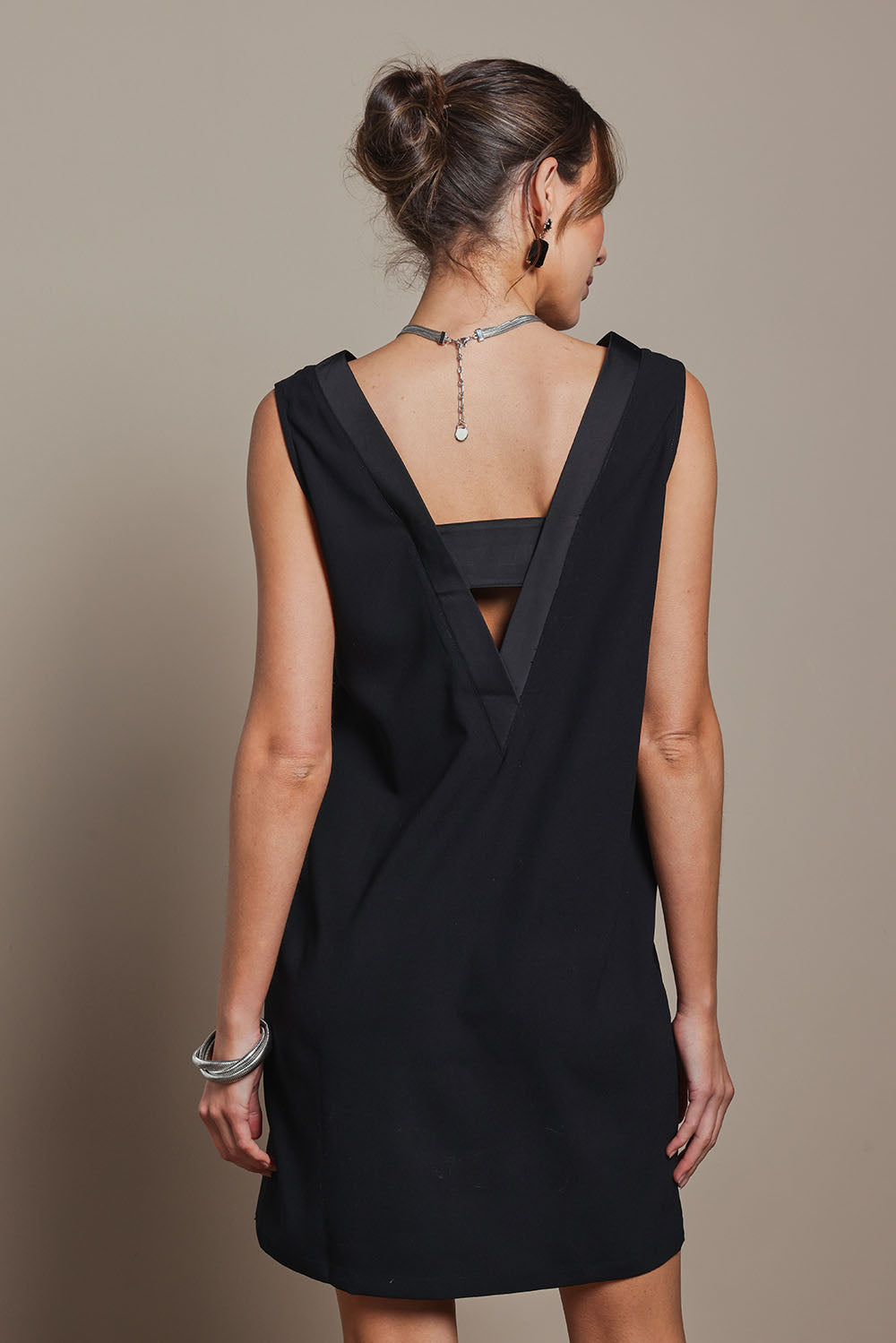 Model Madeline wearing the Meave Tuxedo Dress in colour Black (Black), from the back