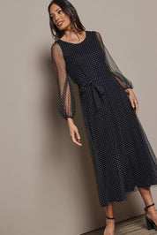 Model Amanda wearing size 10 of the Lorraine Dress in colour Whitedot (Black), from the front, showing the whole outfit