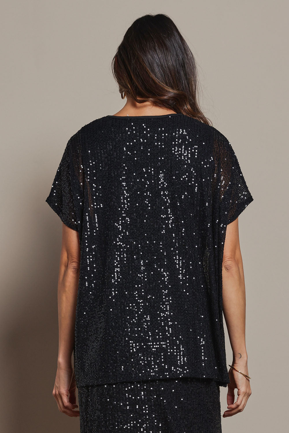 Model Amanda wearing size 10 of the Renee Sequin Top in colour Black (Metallics), from the back