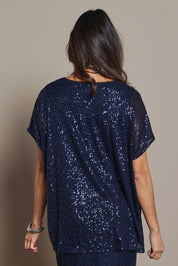 Model Amanda wearing size 10 of the Renee Sequin Top in colour Navy (Metallics), from the back