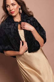 Model Madeline wearing size 10 of the Daphne Faux Fur Cape in colour Black (Black), from the front, cropped image