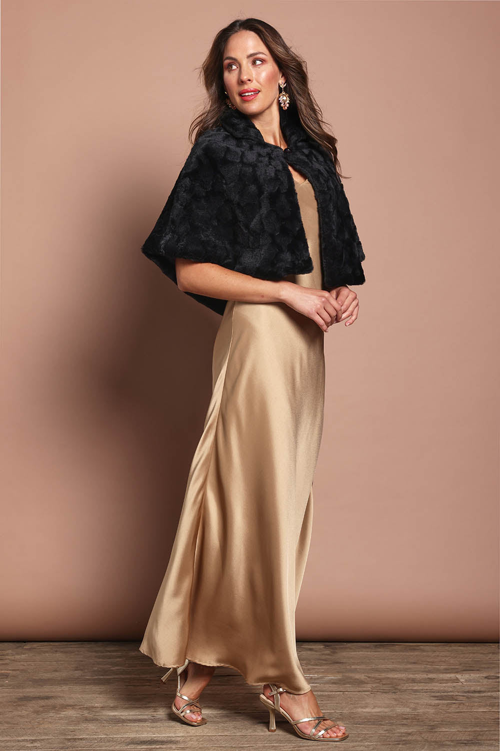 Model Madeline wearing size 10 of the Daphne Faux Fur Cape in colour Black (Black), from the front, showing the whole outfit
