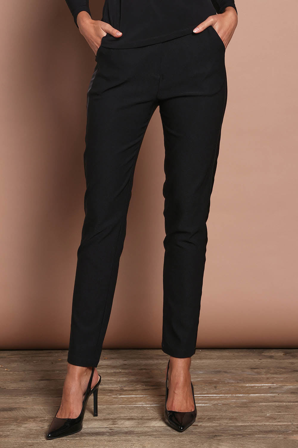 Model Madeline wearing size 10 of the Tiffany Tuxedo Pants in colour Black (Black), from the front, cropped image