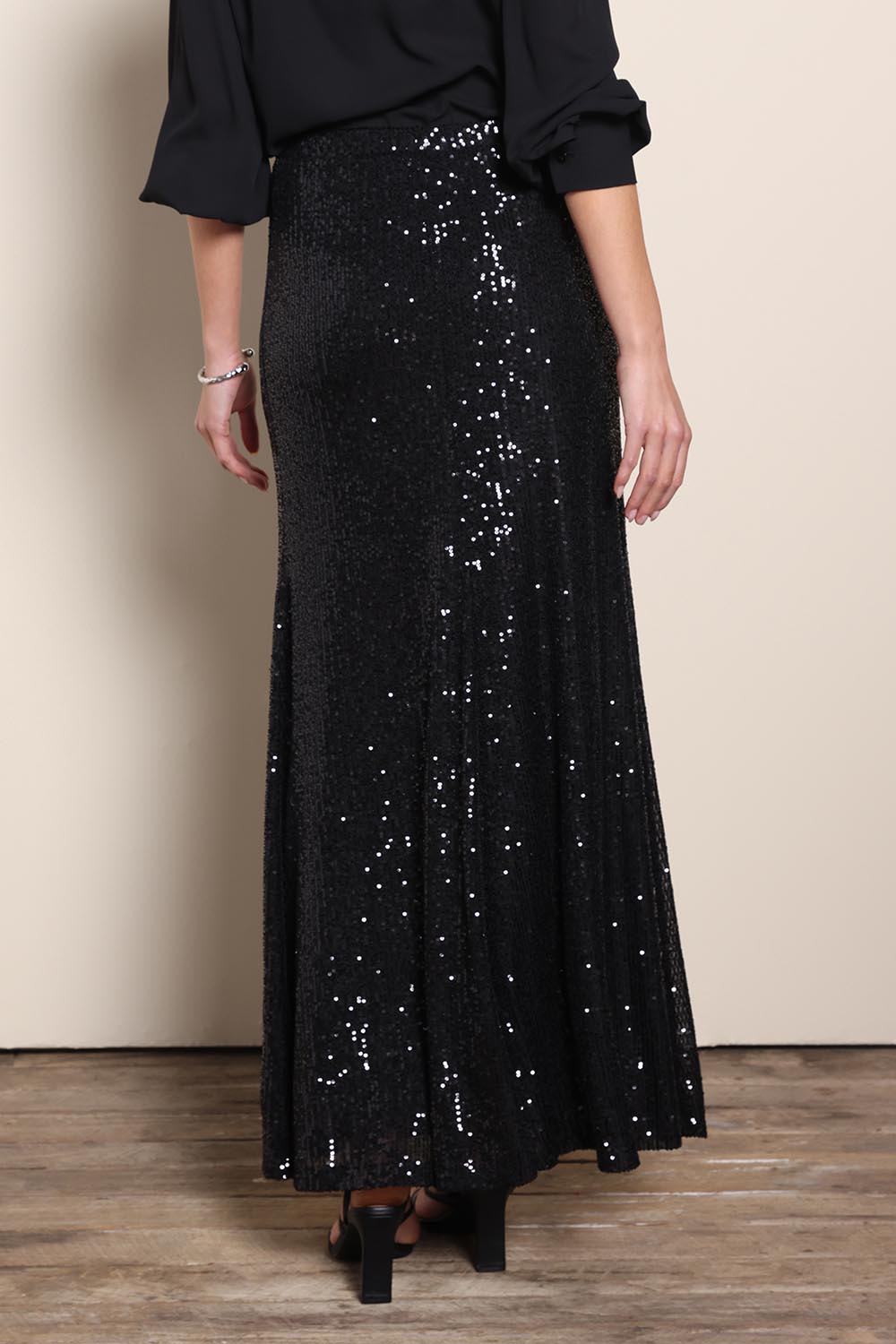 Model Maddiec wearing size 10 of the Remy Sequin Skirt – Black in colour Black, from the back