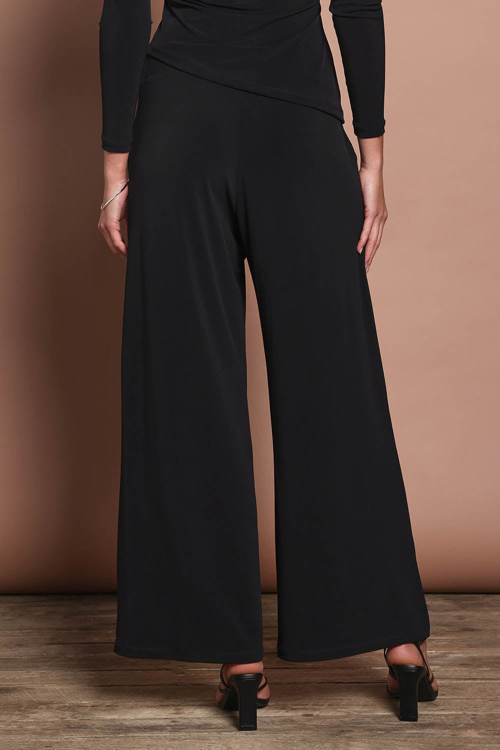 Model Madeline wearing size 10 of the Kristi Pants in colour Black (Black), from the back