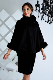 Model Madeline wearing size OneSize of the Brigitte Cape in colour Black (Black), from the front, cropped image