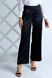 Model Madeline wearing size 10 of the Tina Pants in colour Black (Black), from the front, cropped image