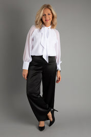 Model Sandy wearing size 10 of the Tina Pants in colour Black (Black), from the front, showing the whole outfit