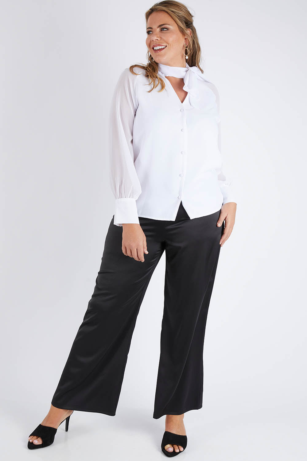 Model Fiona wearing size 16 of the Elena Blouse in colour Snow (White), from the front, showing the whole outfit