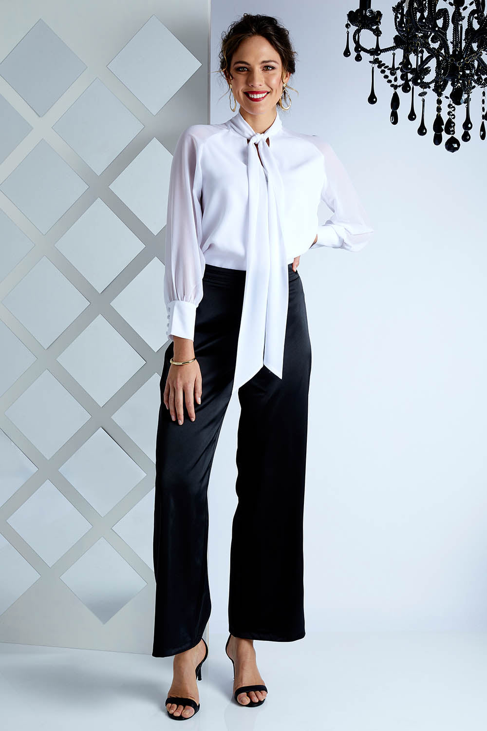 Model Madeline wearing size 10 of the Elena Blouse in colour Snow (White), from the front, showing the whole outfit