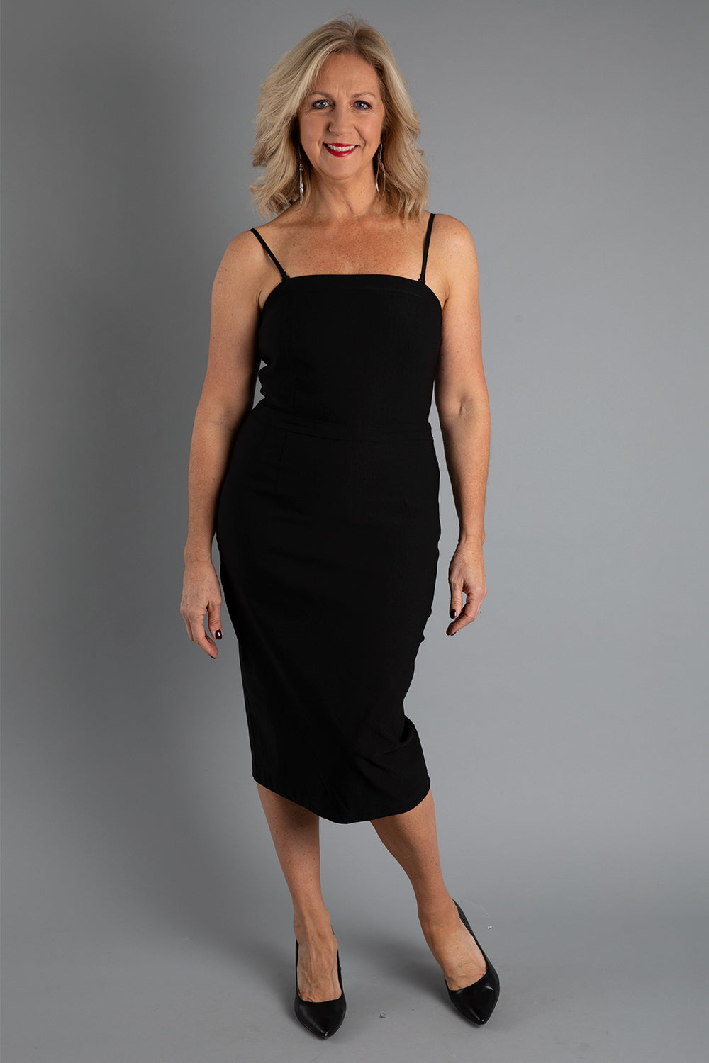 Model Sandy wearing size 10 of the Lola Dress in colour Black (Black), from the front, showing the whole outfit
