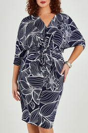 Model Maddy wearing size 16 of The Printed Nancy Dress in colour Navyleaves (Blue), from the front, cropped image