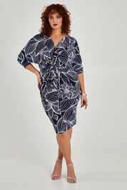 Model Maddy wearing size 16 of The Printed Nancy Dress in colour Navyleaves (Blue), from the front, showing the whole outfit