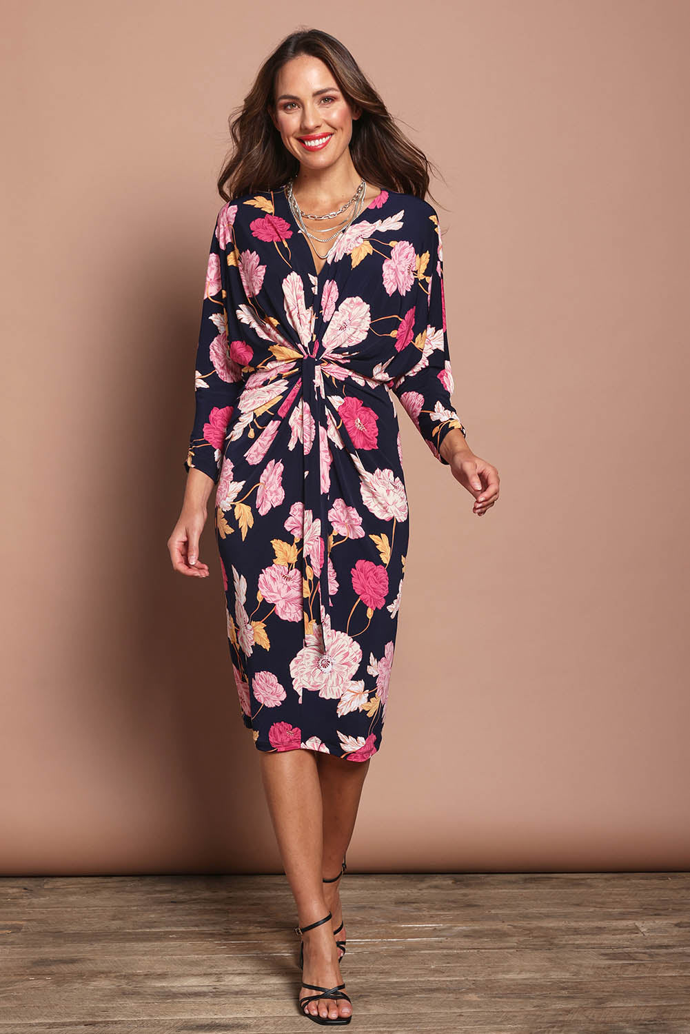 Model Madeline wearing size 10 of The Printed Nancy Dress in colour Poppies (Pink), from the front, showing the whole outfit