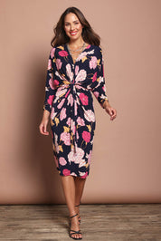 Model Madeline wearing size 10 of The Printed Nancy Dress in colour Poppies (Pink), from the front, showing the whole outfit