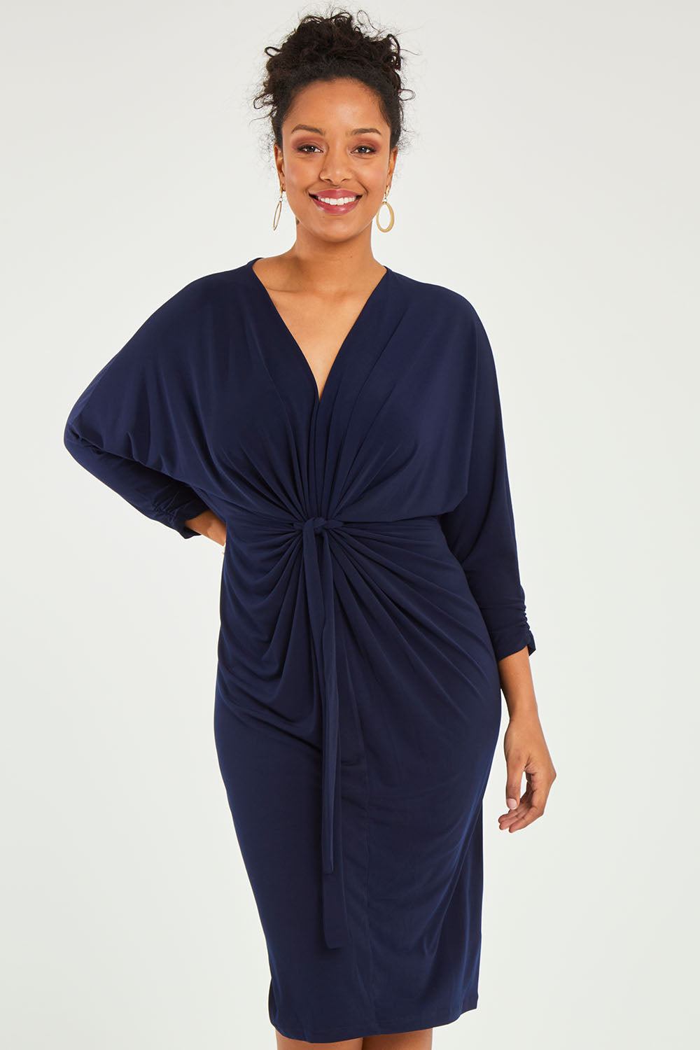 Model Noli wearing size 14 of the Nancy Dress in colour Navy (Blue), from the front, cropped image