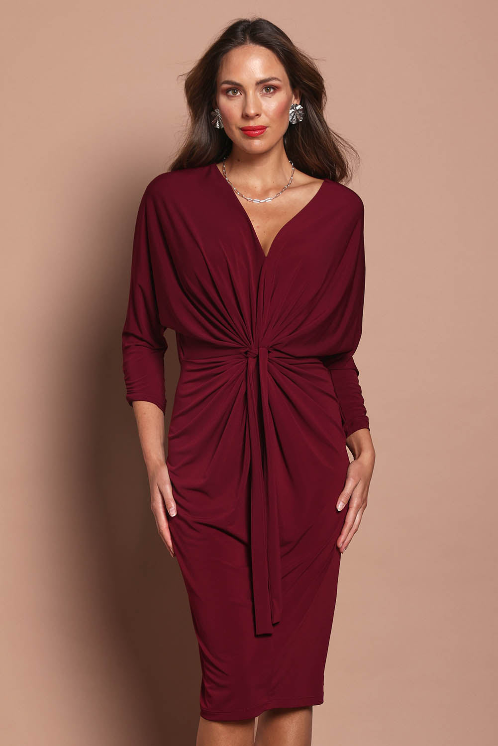 Model Madeline wearing size 10 of the Nancy Dress in colour Port (Red), from the front, cropped image