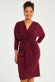 Model Noli wearing size 14 of the Nancy Dress in colour Port (Red), from the back