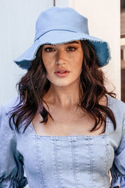 A model wearing the Nika Bucket Hat in colour Denim (Blue), from the front, showing the whole outfit