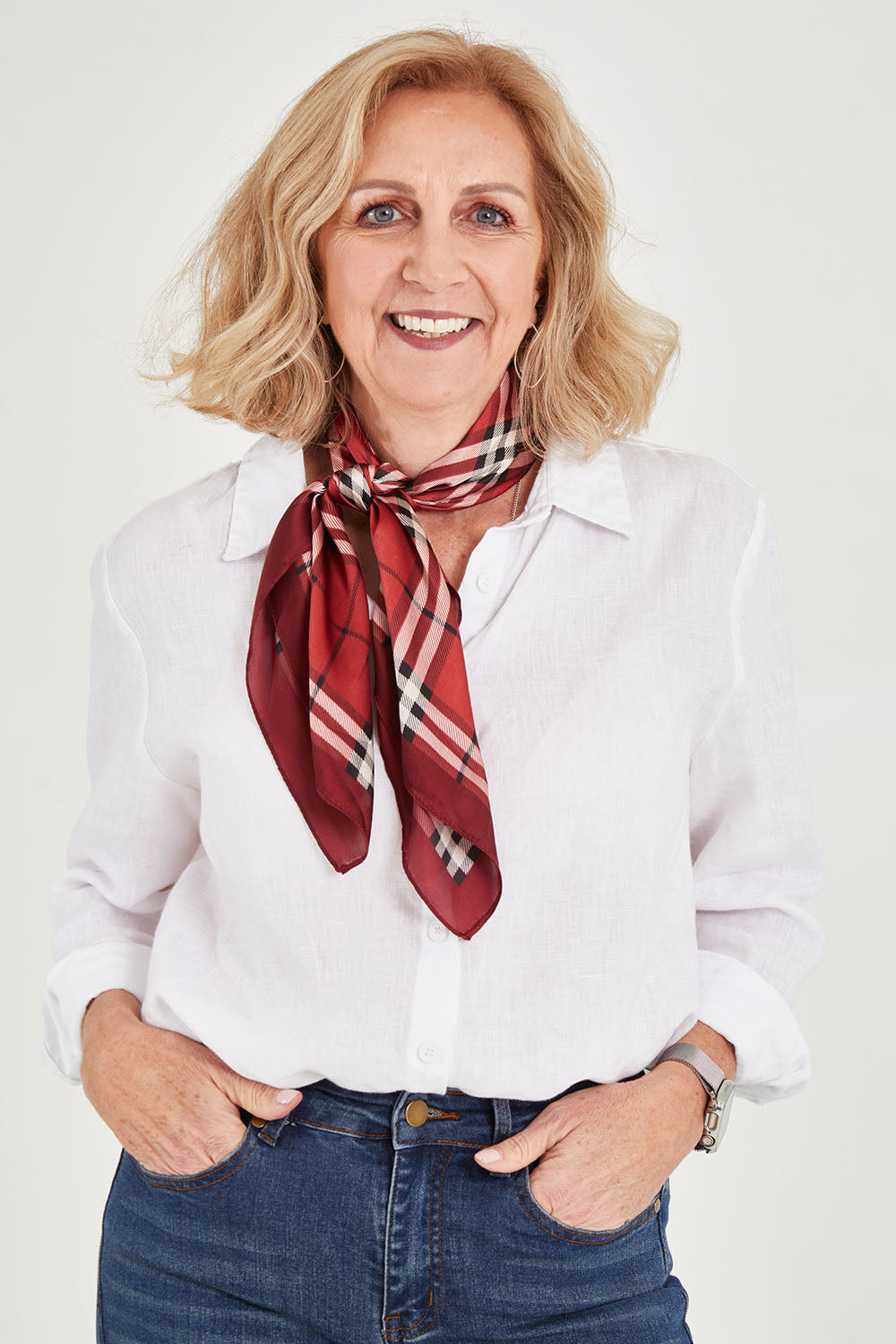 Model Sandy wearing size OneSize of the Merin Hair Scarf in colour Redcheck (Red), from the front, cropped image