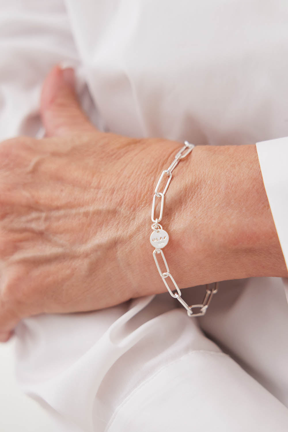A model wearing the Vista Chain Bracelet in colour Silver (Metallics), from the front, showing the whole outfit