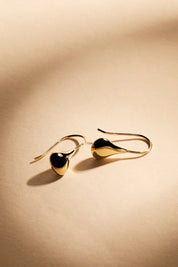 A model wearing the Baby Tears Earrings in colour Gold (Metallics), from the front, showing the whole outfit