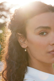 A model wearing the Baby Tears Earrings in colour Gold (Metallics), from the front, showing the whole outfit