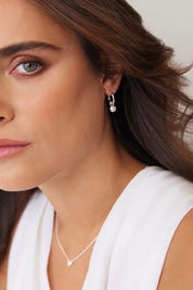 A model wearing the Heavenly Pearl Earrings in colour Silver (Metallics), from the front, showing the whole outfit