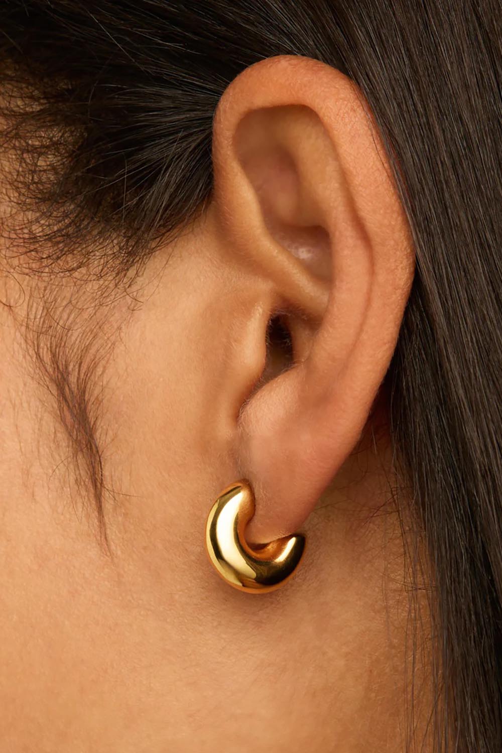 A model wearing the Moonbow Gold Earring in colour Gold (Metallics), from the front, showing the whole outfit