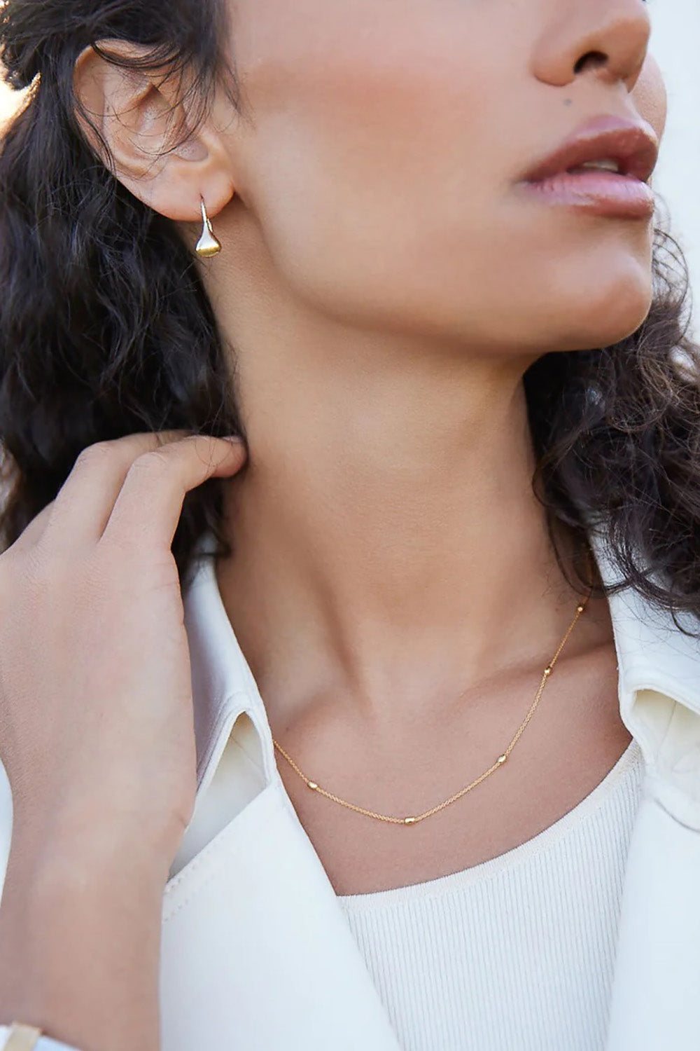 A model wearing the Like A Breeze Necklace in colour Gold (Metallics), from the front, showing the whole outfit