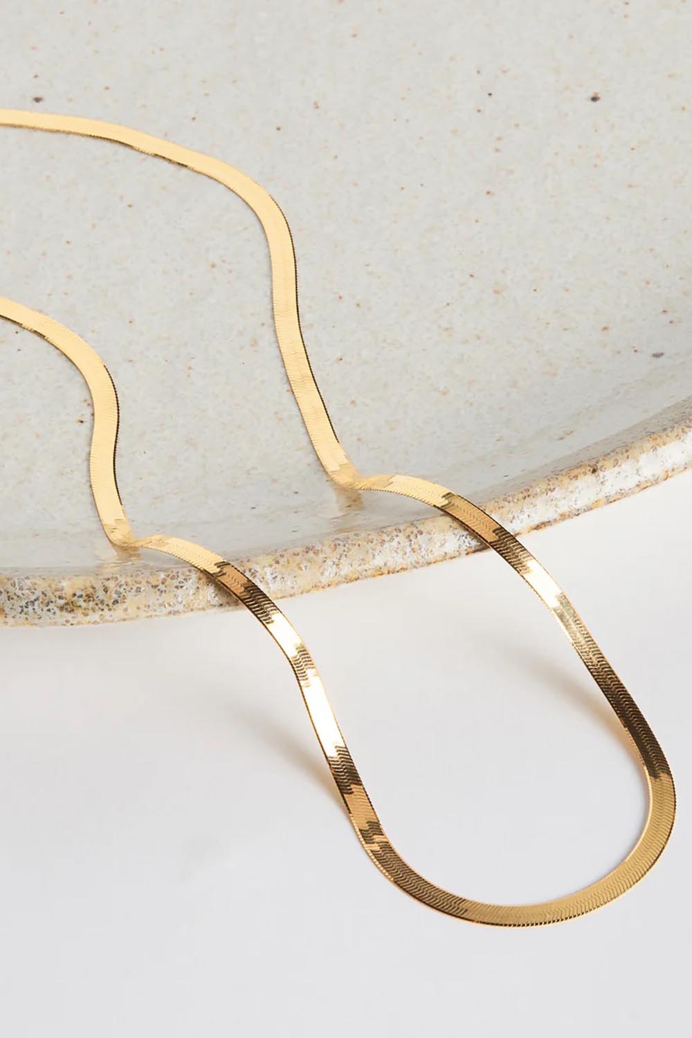 A model wearing the Herringbone Yellow Gold Necklace in colour Gold (Metallics), from the front, showing the whole outfit