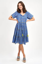 A model wearing the Libra Dress in colour Patolablue (Blue), from the front, showing the whole outfit