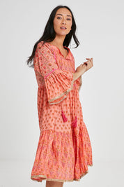 Model Katie wearing size S of the Belmont Dress in colour Coralpatch (Pink), from the front, cropped image