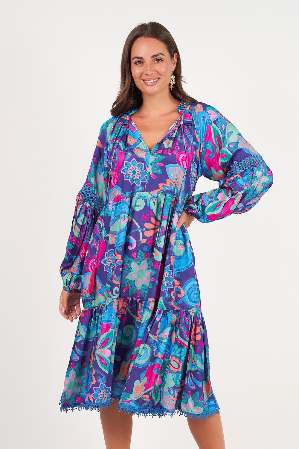 A model wearing the Molly Dress in colour Enigma (Blue), from the front, cropped image