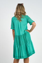 A model wearing the Heather S/S Cotton Dress in colour Luca (Green), from the back