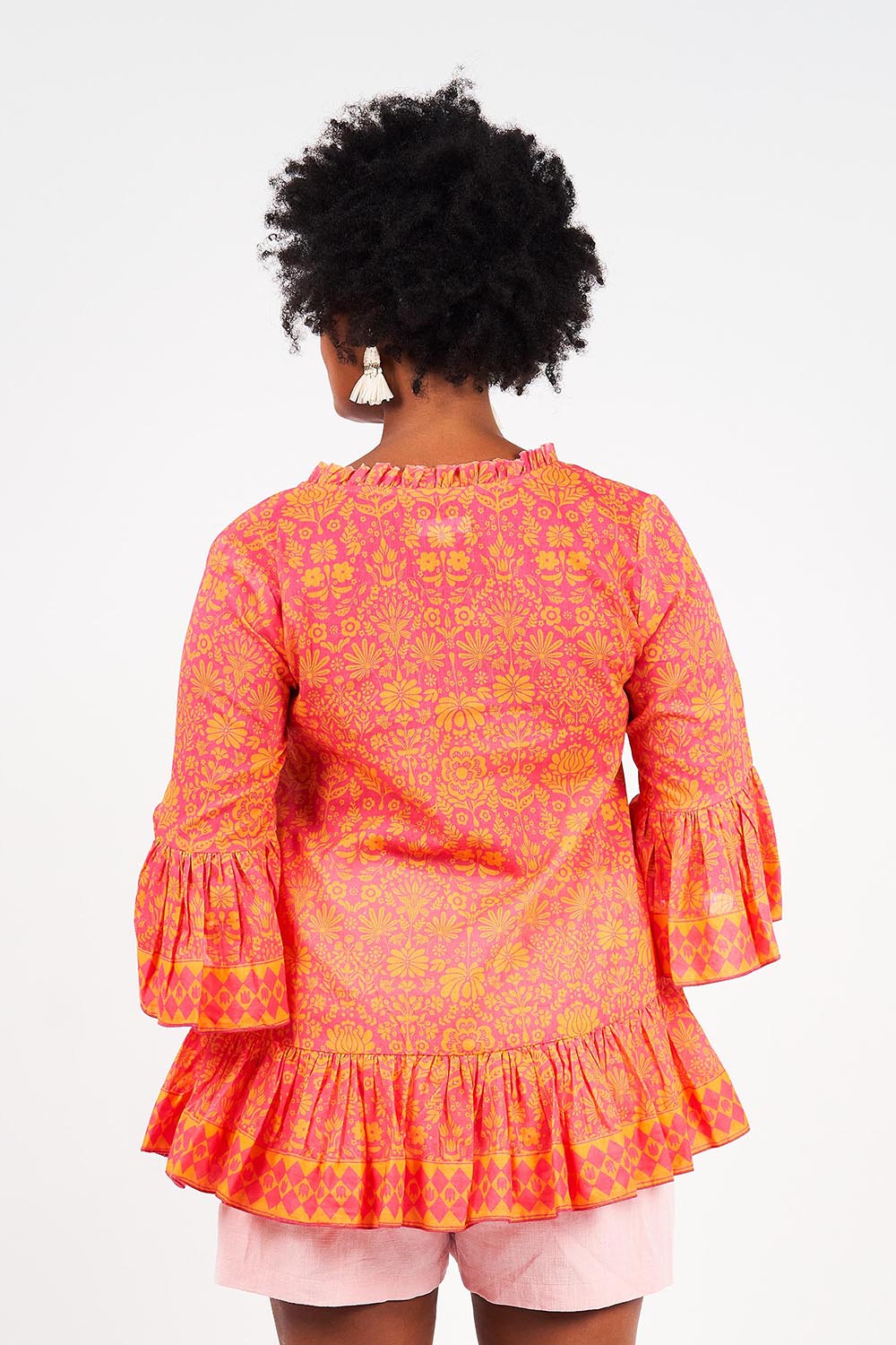 A model wearing the Hacienda Cotton Tunic in colour Majestic (Pink), from the back